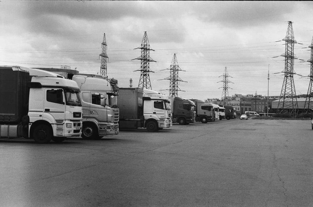A Black And White Photo Of Trucks Parked In A Lot